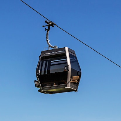 Die Kabine einer Seilbahn vor blauem Himmel.