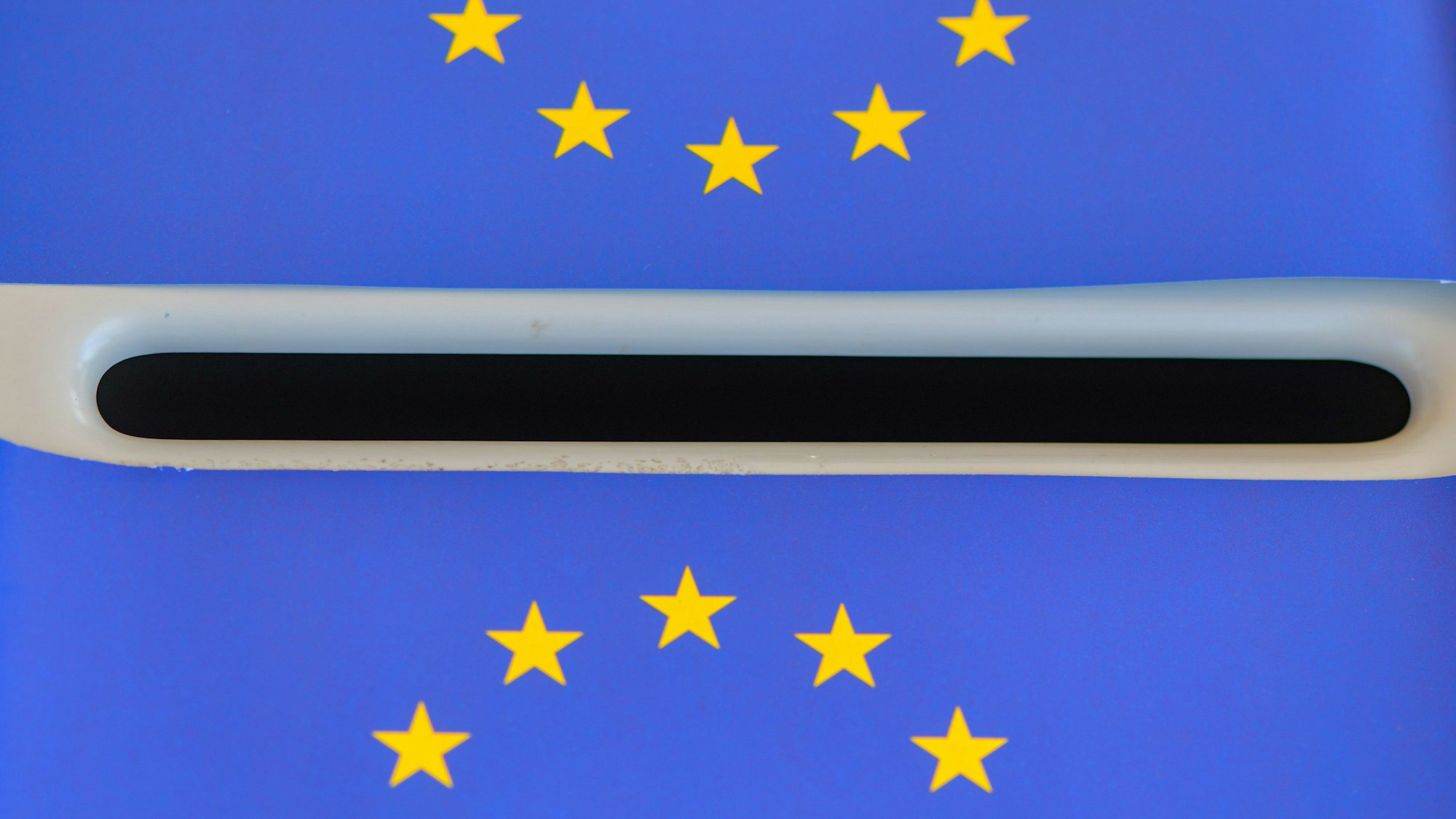 Europa-Fähnchen liegen auf einer Wahlurne (gestellte Aufnahme).