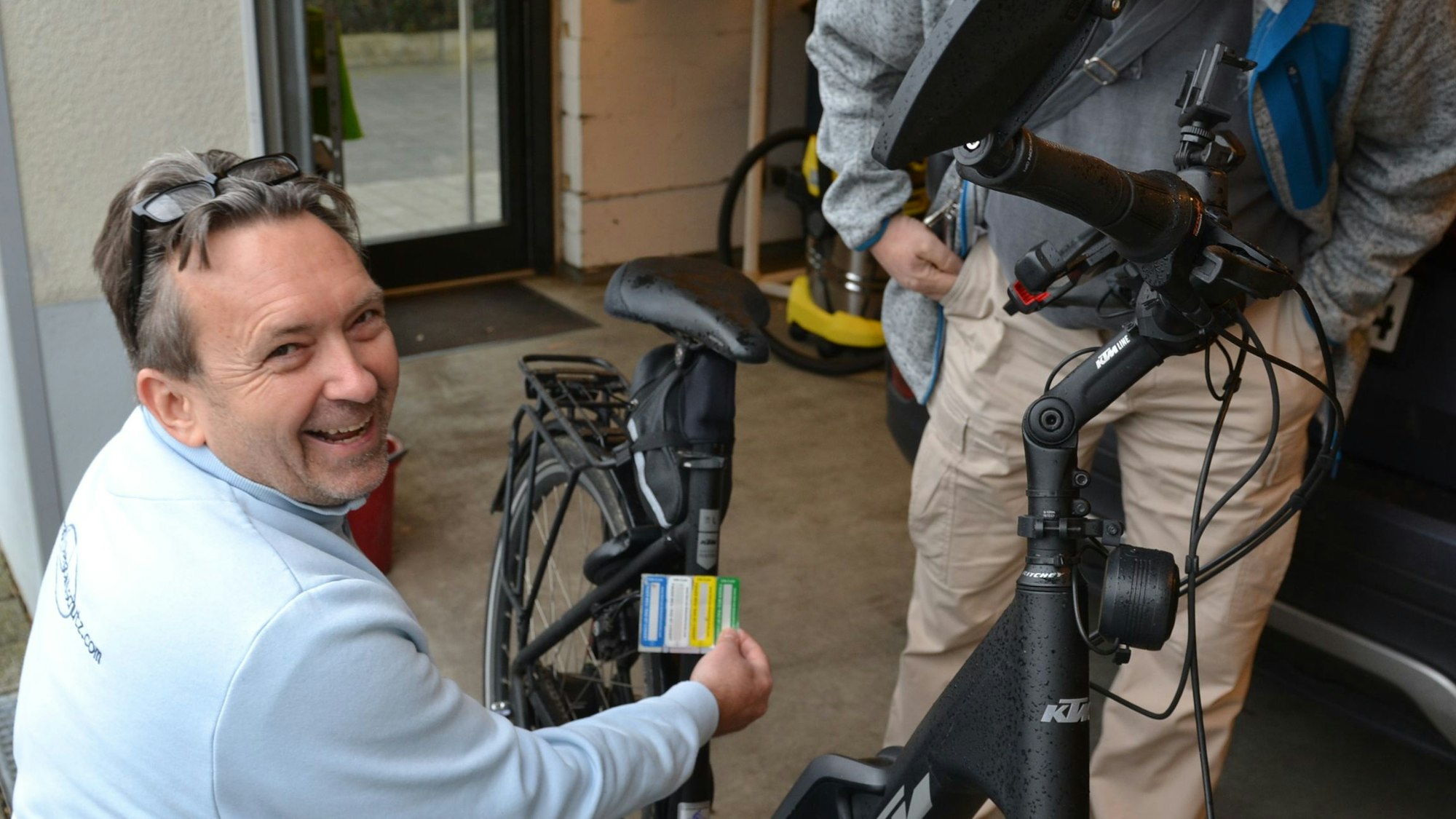 Ein Mann bereitet die Codierung am Fahrrad vor. Dessen Besitzer schaut ihm dabei zu.