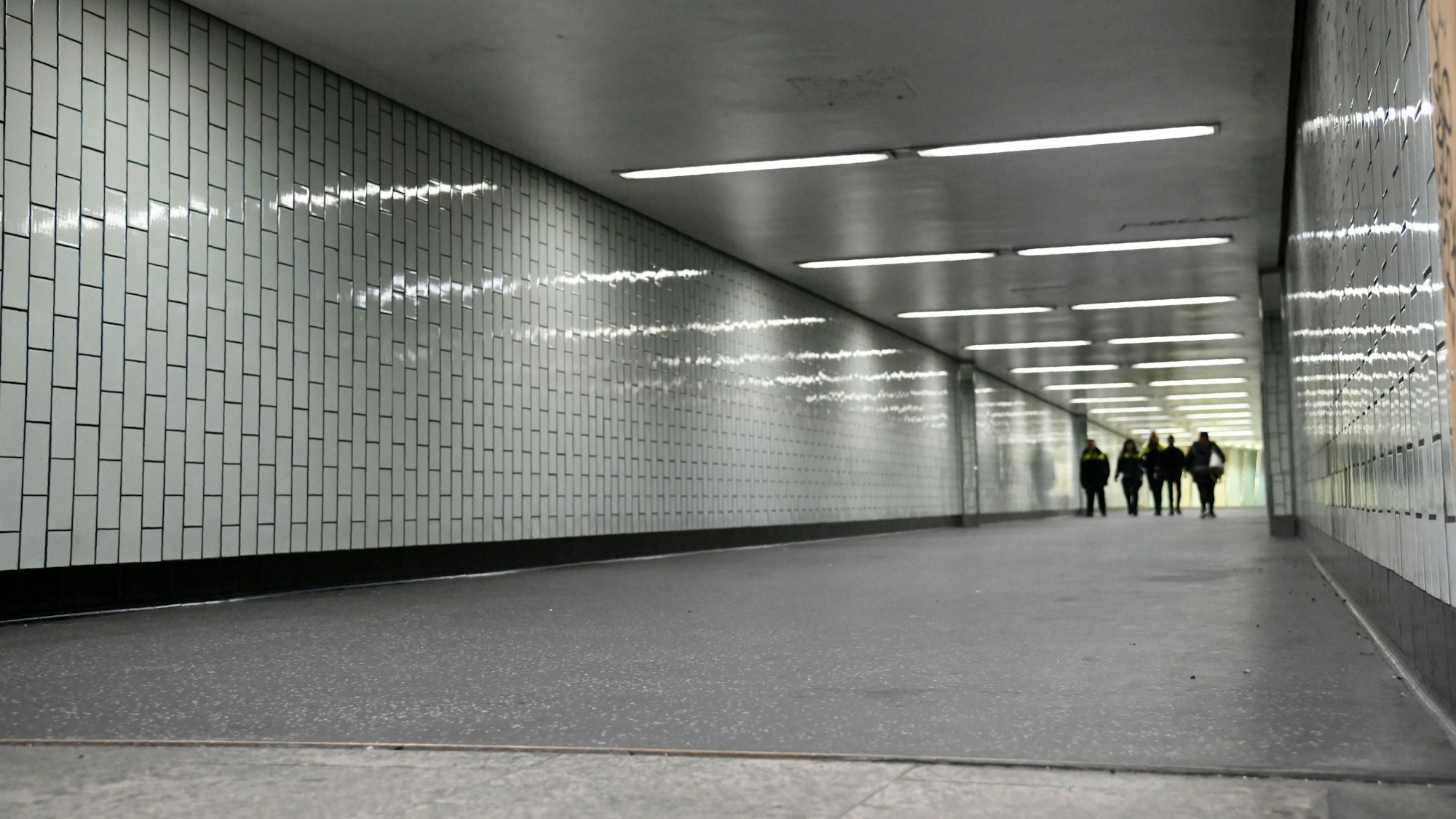 Ein langer grauer Tunnel, der von Neonröhren erleuchtet wird.