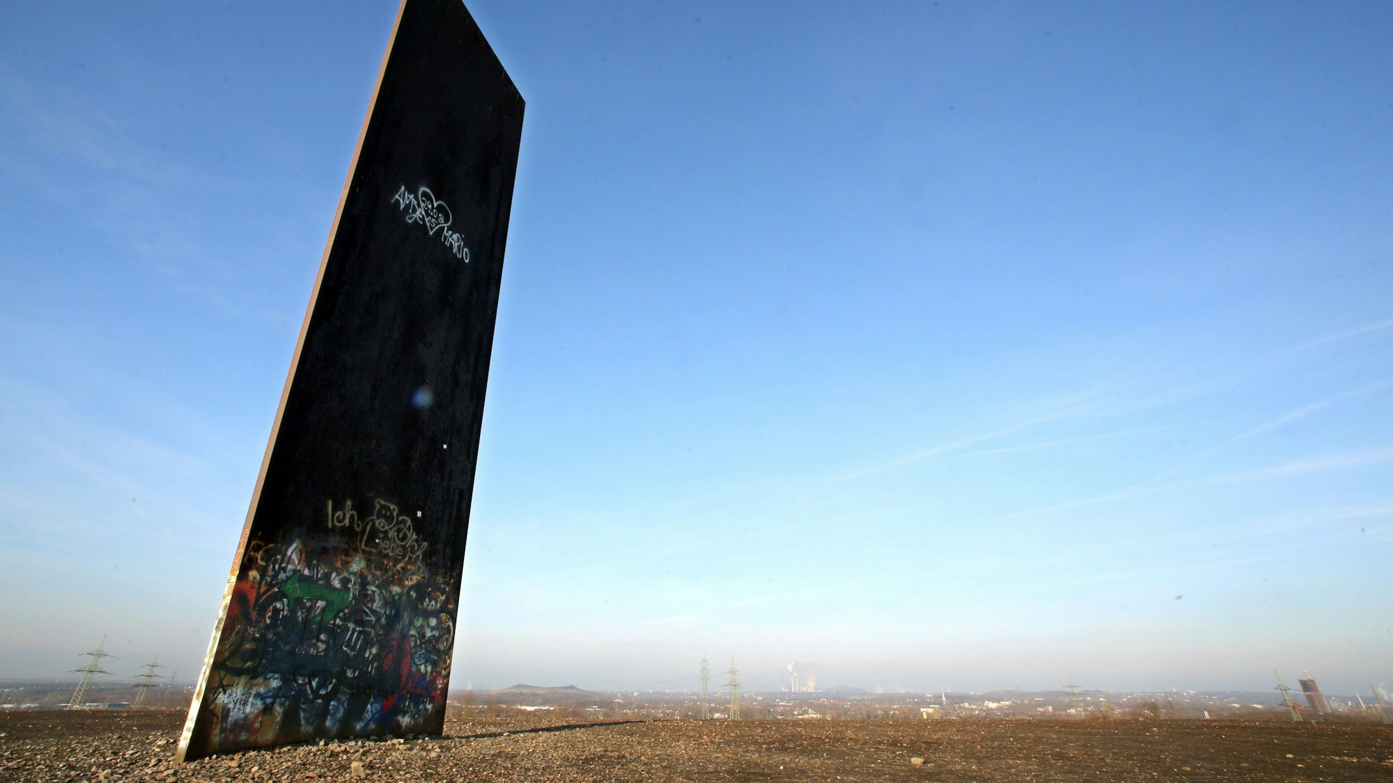 In den blauen Himmel ragt auf der Schurenbachhalde in Essen (Nordrhein-Westfalen) die etwa 15 Meter hohe stählerne Bramme von Bildhauer Richard Serra.