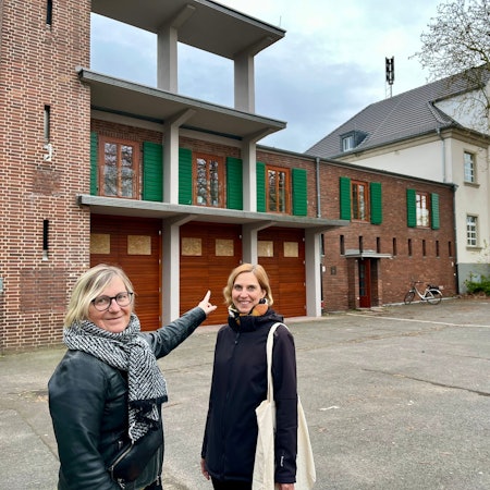 Andrea Pesch und Projektleiterin Kristina Gehrmann stehen vor der restaurierten Feuerwache in Bürrig.