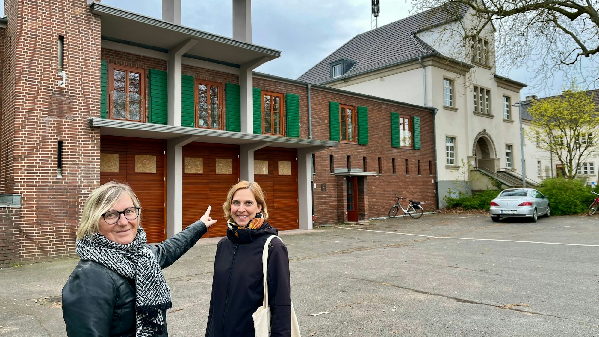 Andrea Pesch und Projektleiterin Kristina Gehrmann stehen vor der restaurierten Feuerwache in Bürrig.