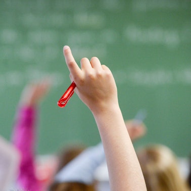 Eine Schülerin meldet sich in einem Klassenzimmer.