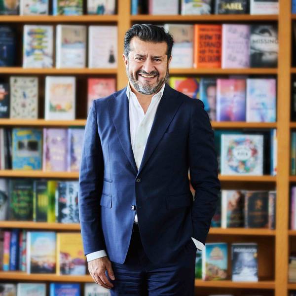 Soheil Dastyari steht vor einem Bücherregal.