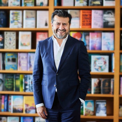 Soheil Dastyari steht vor einem Bücherregal.