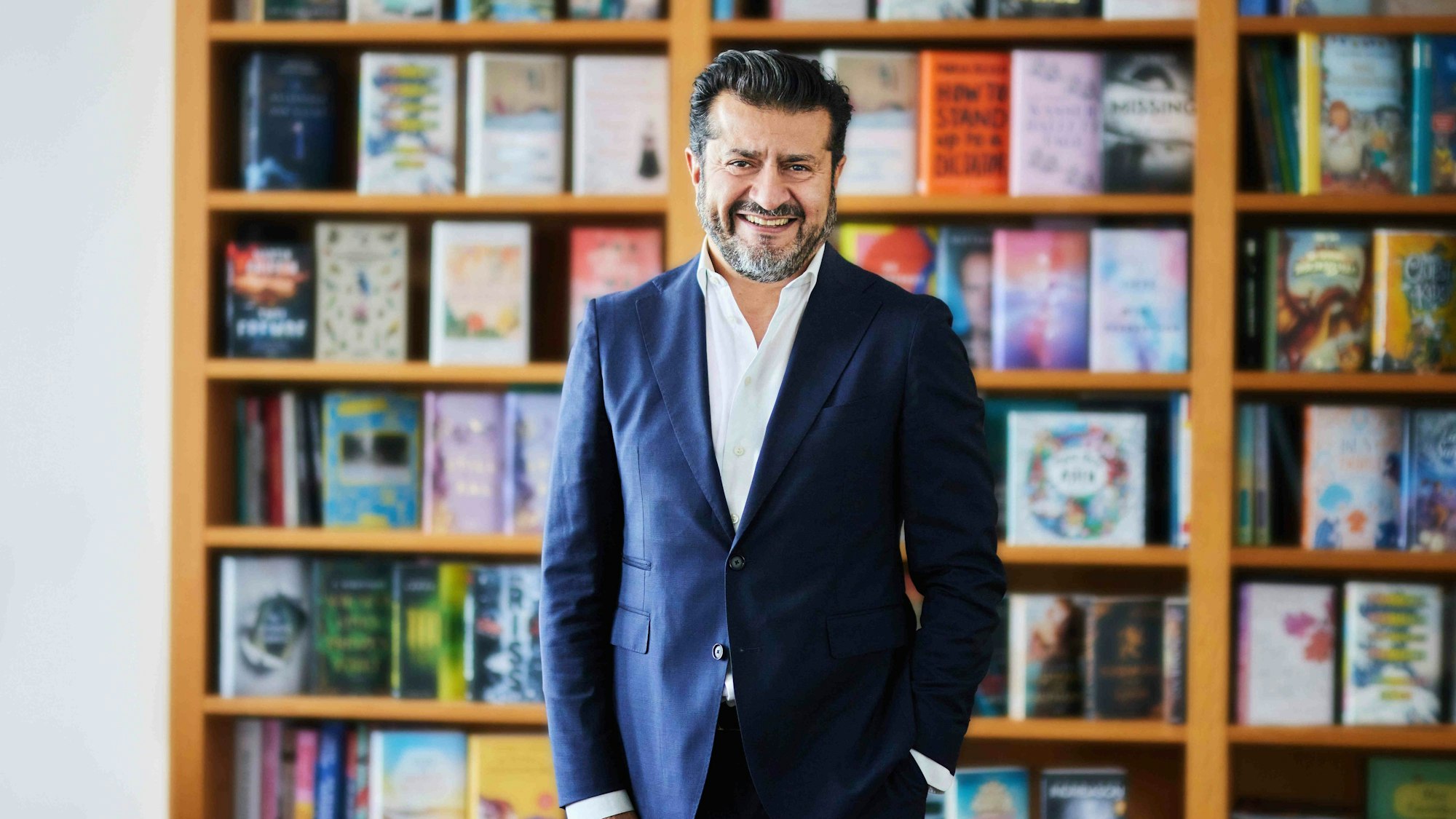 Soheil Dastyari steht vor einem Bücherregal.