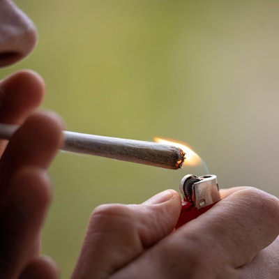 Ein Mann zündet sich einen Joint an.