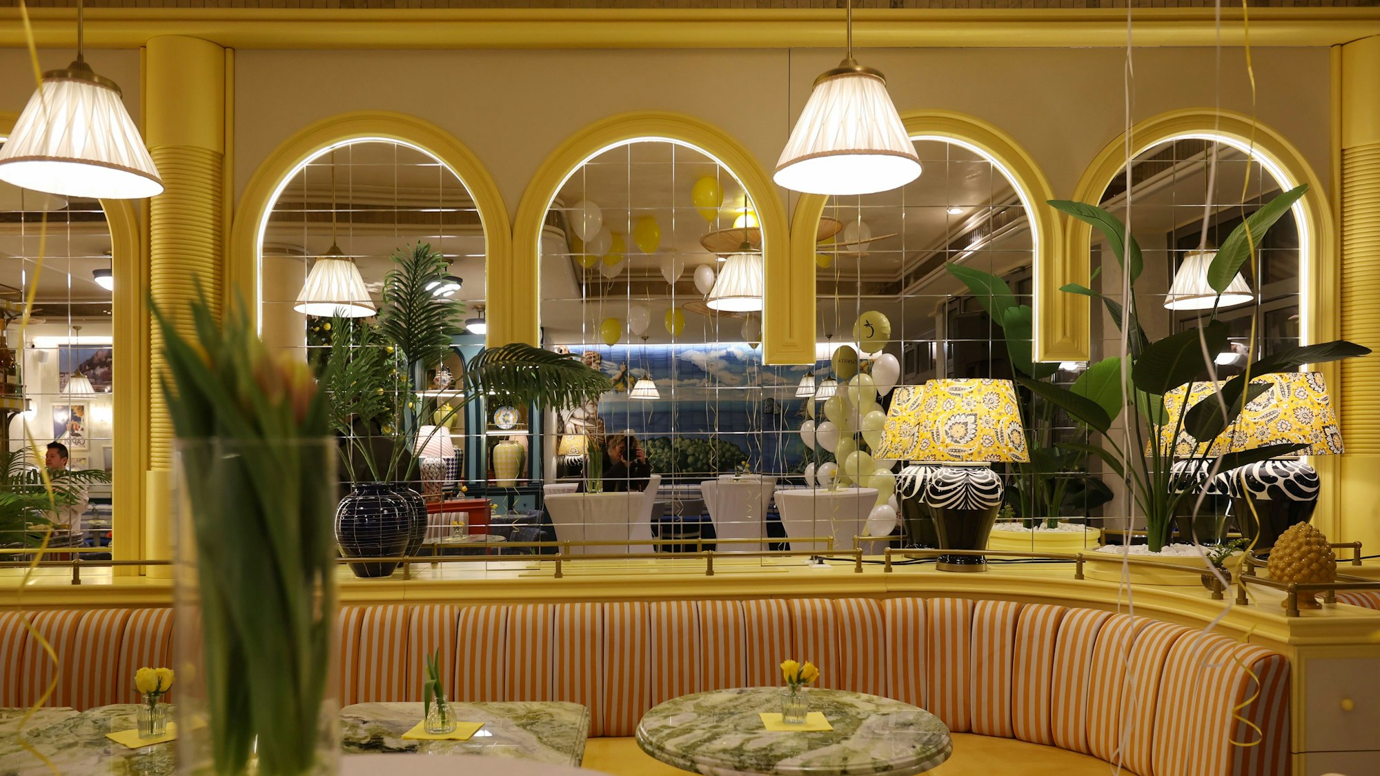 Sitzbank, Tische und gelbe Einrichtung im Café Caprista