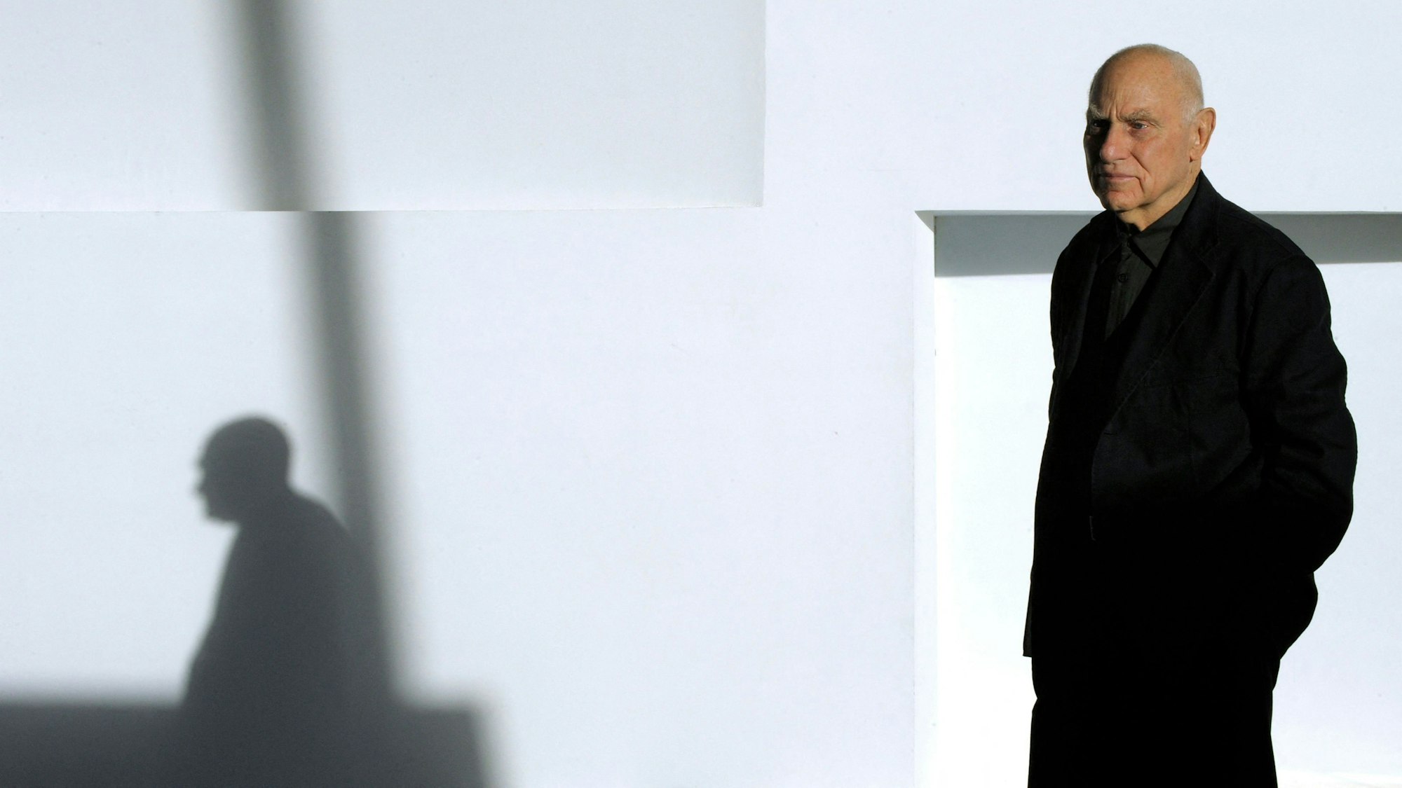 Richard Serra trägt schwarz und schaut in die Kamera.