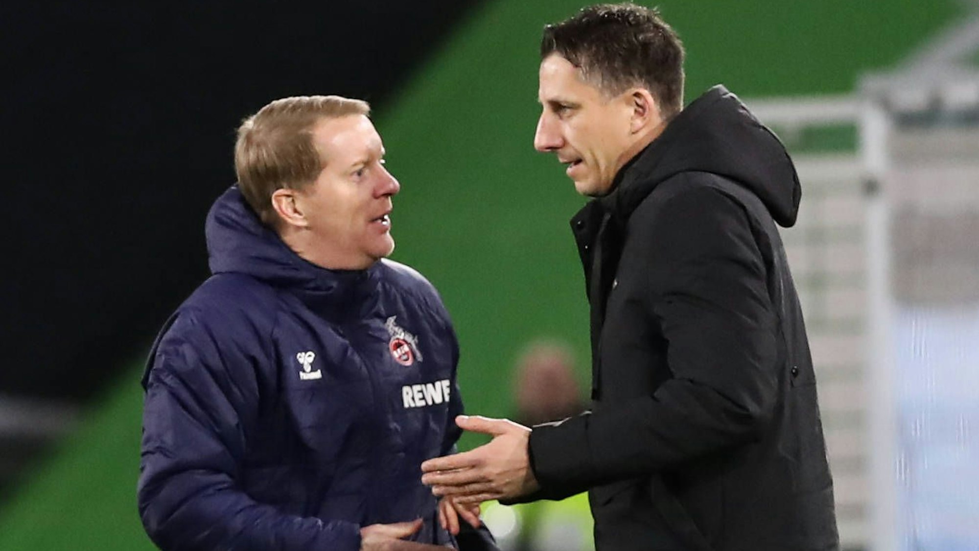 Geschäftsführer Christian Keller (r.) vom 1. FC Köln spricht mit Trainer Timo Schultz vor dem Bundesligaspiel beim VfL Wolfsburg.