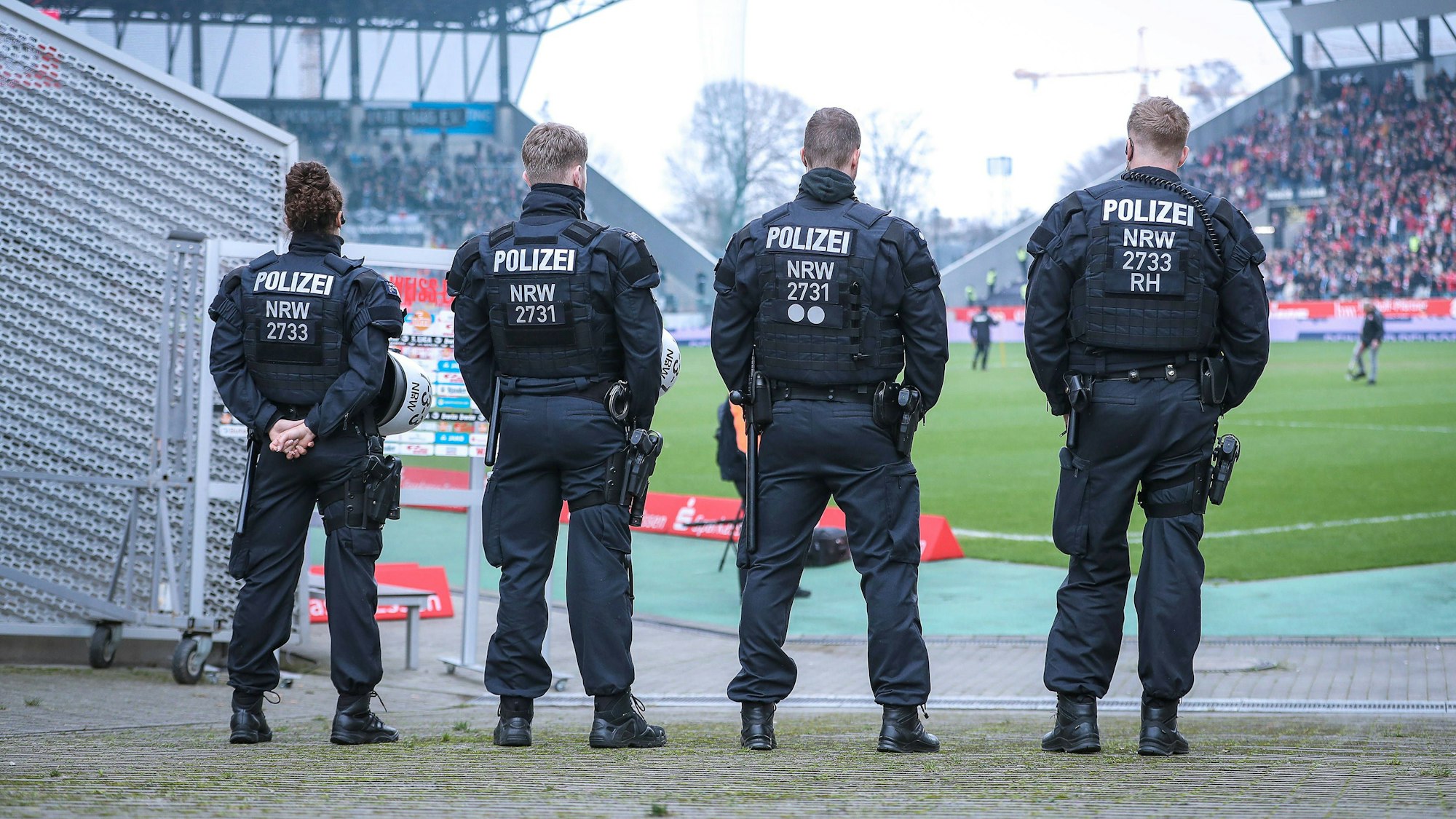 Polizisten stehen am Rande eines Fußballstadions