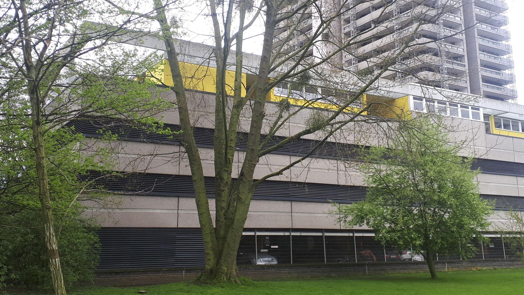 Die Kita (gelbes Gebäude) liegt auf den Parkdecks des Colonia-Hauses. Wegen der laufenden Balkonsanierung am Hochhaus hat die Kita bis auf weiteres geschlossen, die Gruppen sind in zwei andere Kindergärten verlegt.
