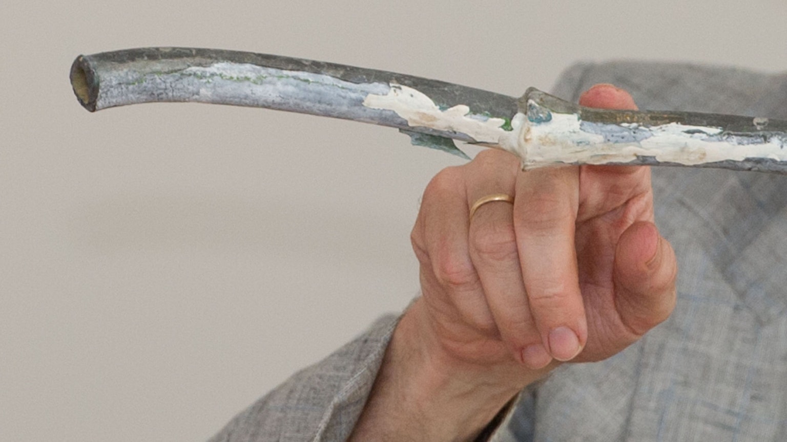 Ein Mann zeigt mit einem Finger auf ein Wasserrohr.