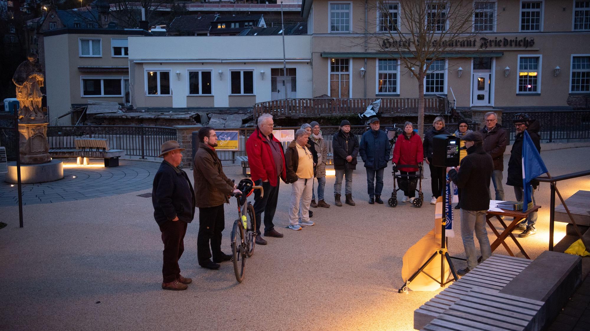 Eine Gruppe von Menschen steht auf dem Nepomuk-Platz in Gemünd.