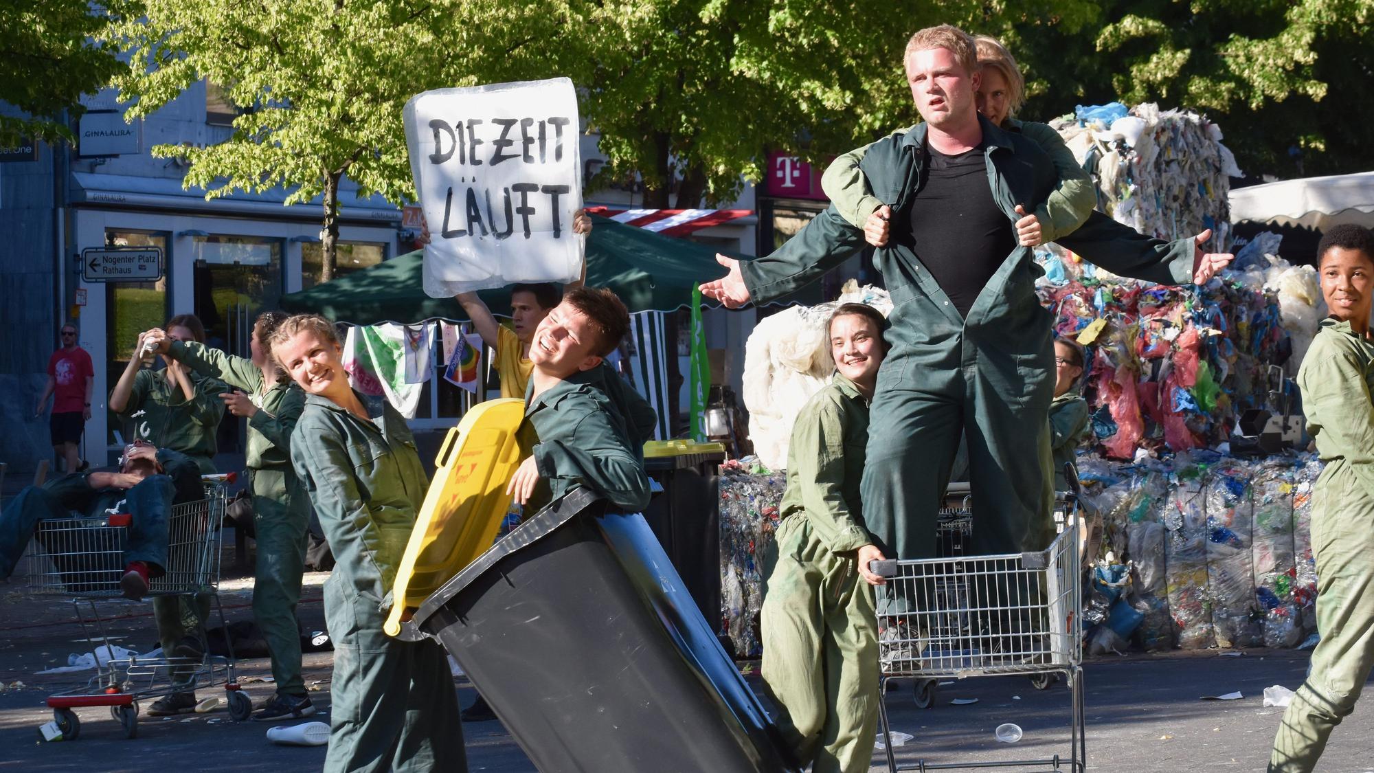 Junge Schauspieler in Mülltonnen und Einkaufswagen
