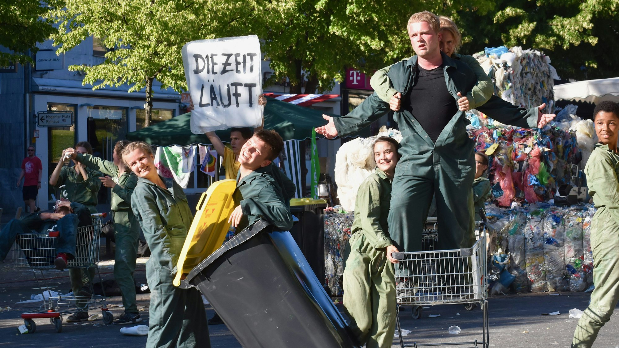 Junge Schauspieler in Mülltonnen und Einkaufswagen