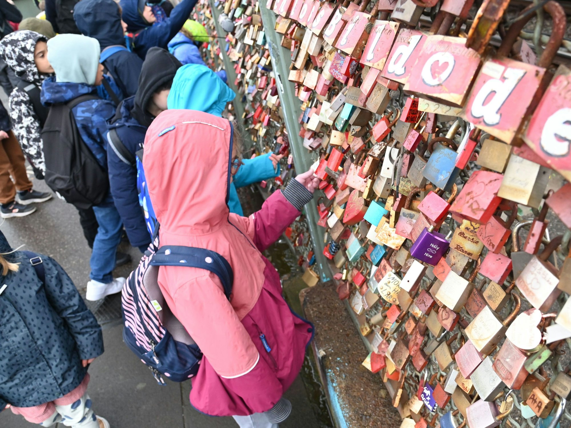 Kinder betrachten die sogenannten Liebesschlösser auf der Kölner Hohenzollernbrücke.
