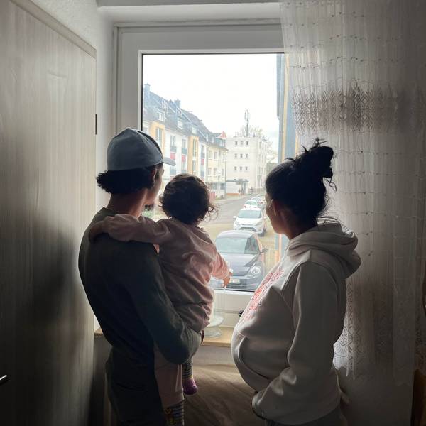 Silhouette einer dreiköpfigen Familie: Vater mit Tochter auf dem Arm, Mutter rechts, gucken aus dem Fenster