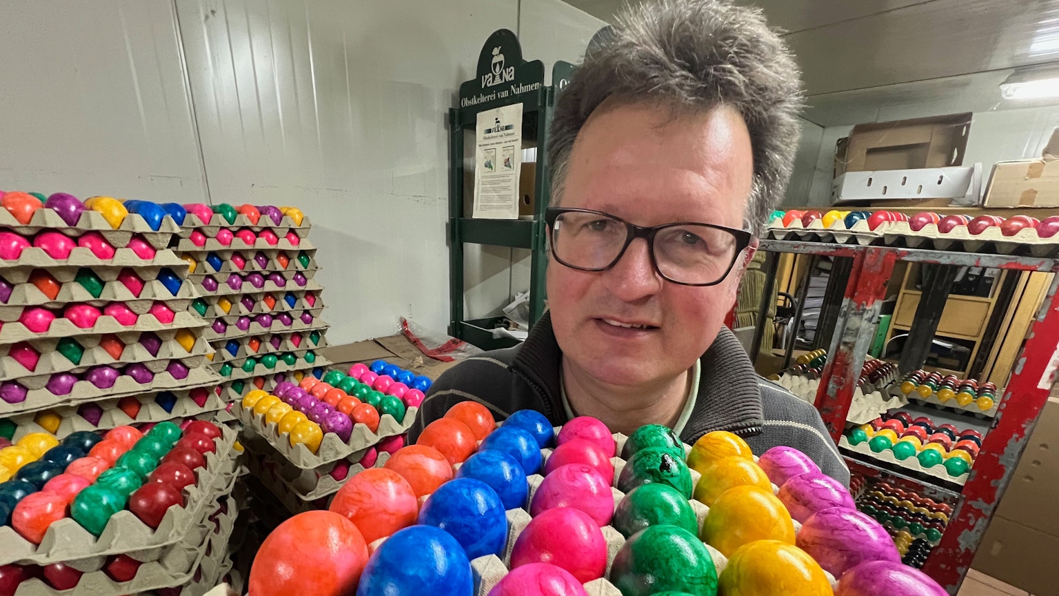 Das Bild zeigt den Landwirt Martin Füngeling aus Hürth mit mehreren Brettern bunter Eier.