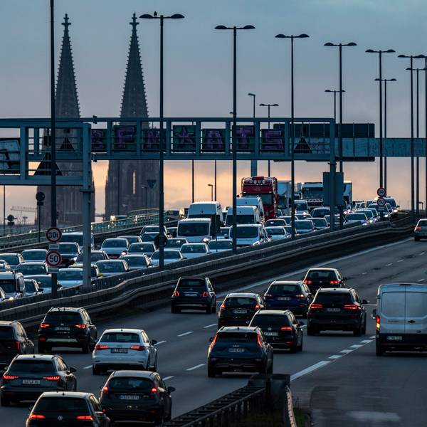 Autos stehen auf einer Brücke im Stau, im Hintergrund ist der Kölner Dom zu sehen.