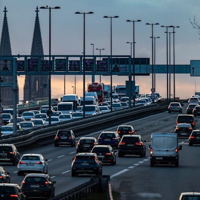 Autos stehen auf einer Brücke im Stau, im Hintergrund ist der Kölner Dom zu sehen.