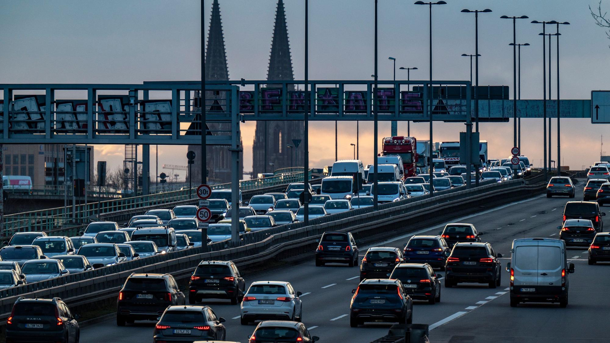 Autos stehen auf einer Brücke im Stau, im Hintergrund ist der Kölner Dom zu sehen.