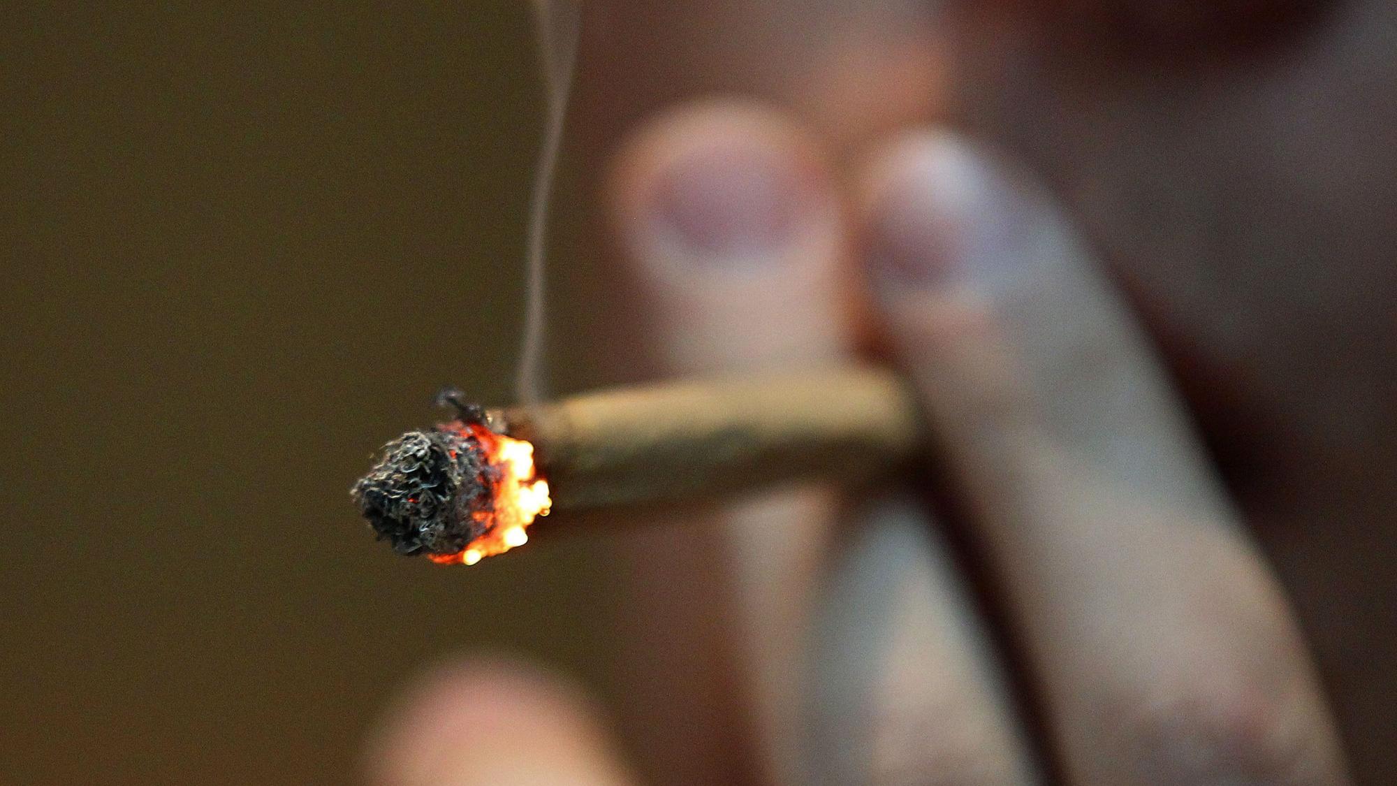 Ein Mann raucht einen Joint mit Marihuana.