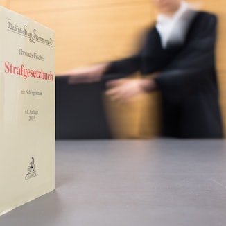 Gesetzbücher stehen auf einem Richtertisch.