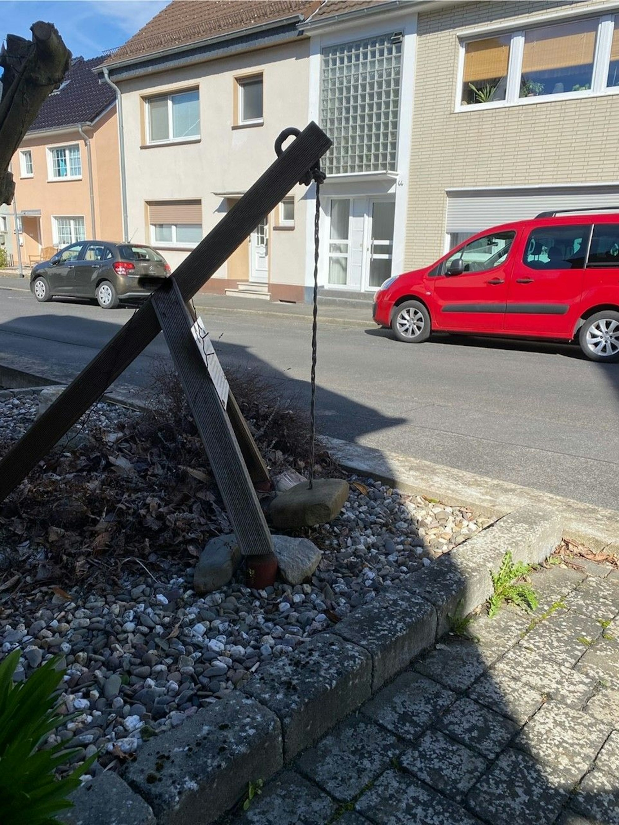 Das Bild zeigt ein Gerät im Vorgarten eines Hauses. Dort ist ein Schild montierte. Auf dem Schild findet man den nächsten Buchstaben, den man für das Lösungswort benötigt.