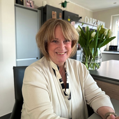 Eine Frau sitzt in einer Küche.