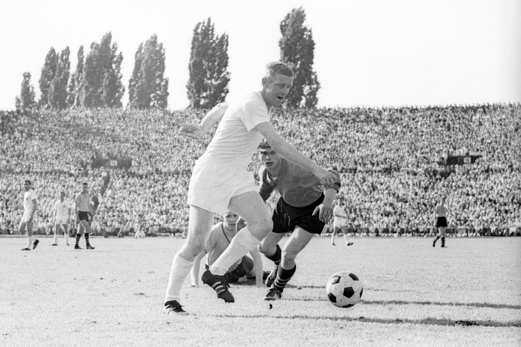 Karl-Heinz Schnellinger (l.) vom 1. FC Köln legt im Juni 1963 im Endspiel um die Meisterschaft den Ball an Torwart Bernhard Wessel von Borussia Dortmund vorbei.