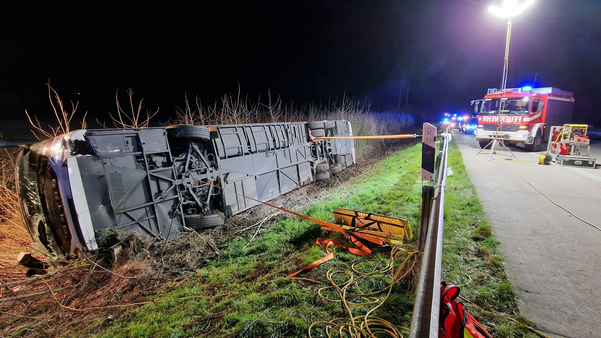 Einsatzkräfte der Feuerwehr arbeiten an einer Unfallstelle auf der Autobahn 44 (A44) an einem verunfallten Bus.