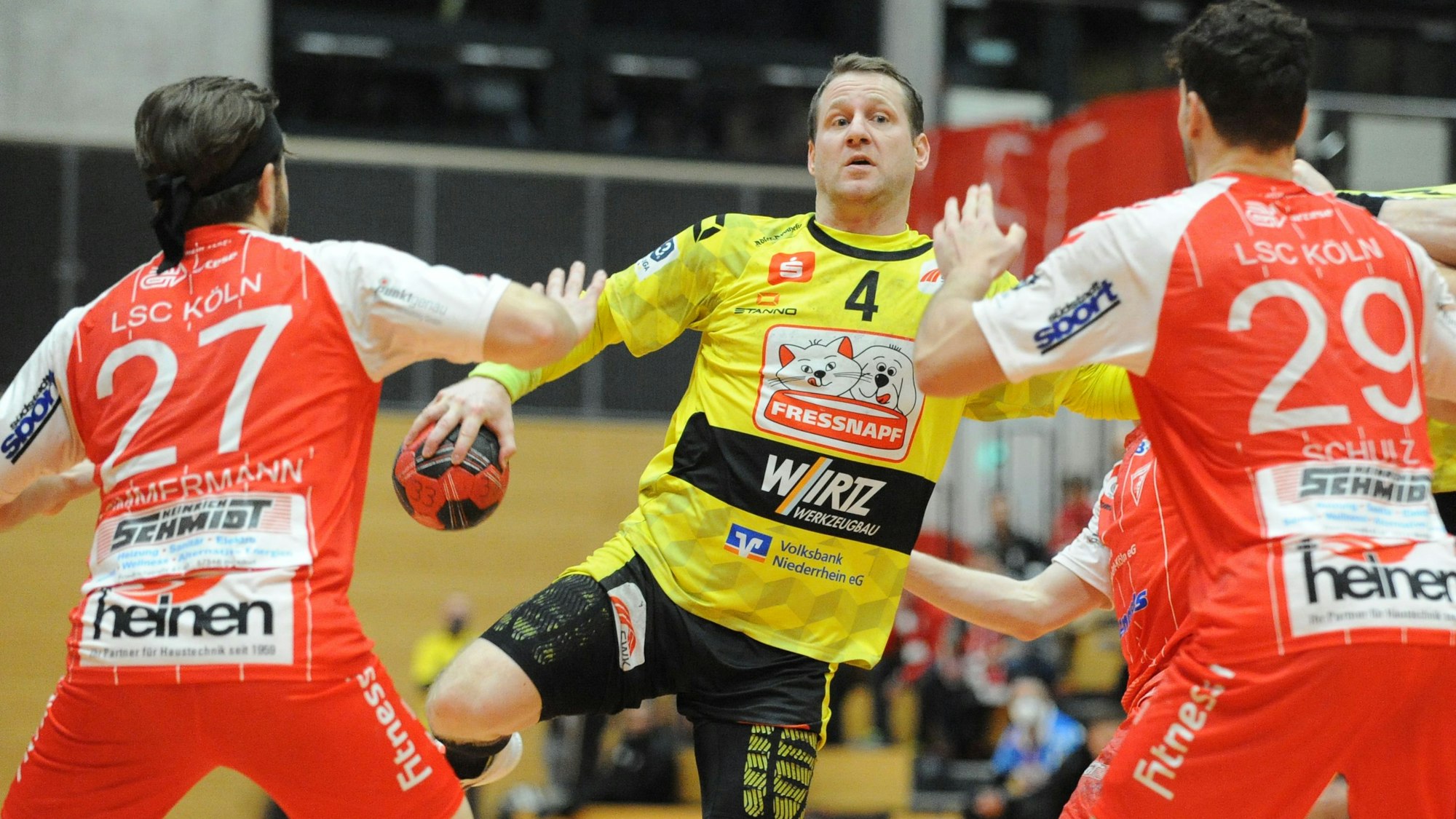 Merten Krings, Mitte, im Kampf gegen Max Zimmermann, links, und Lukas Martin Schulz, rechts, am Sonntag, den 05.12.2021, im Spiel HSG Krefeld Niederrhein gegen Longericher SC im Enni-Sportpark-Rheinkamp in Moers. HSG Krefeld Niederrhein, gelbe Trikots, spielt gegen Longericher SC, rote Trikots, in der 3. Handball-Bundesliga, Saison 2021/2022. Foto: Oleksandr Voskresenskyi / FUNKE Foto Services