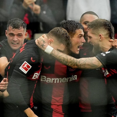 Leverkusen's Patrik Schick, center, celebrates with Leverkusen's Robert Andrich, right, after scoring the decisive goal during the German Bundesliga soccer match between Bayer Leverkusen and TSG Hoffenheim at the BayArena in Leverkusen, Germany, Saturday, March 30, 2024. (AP Photo/Martin Meissner)