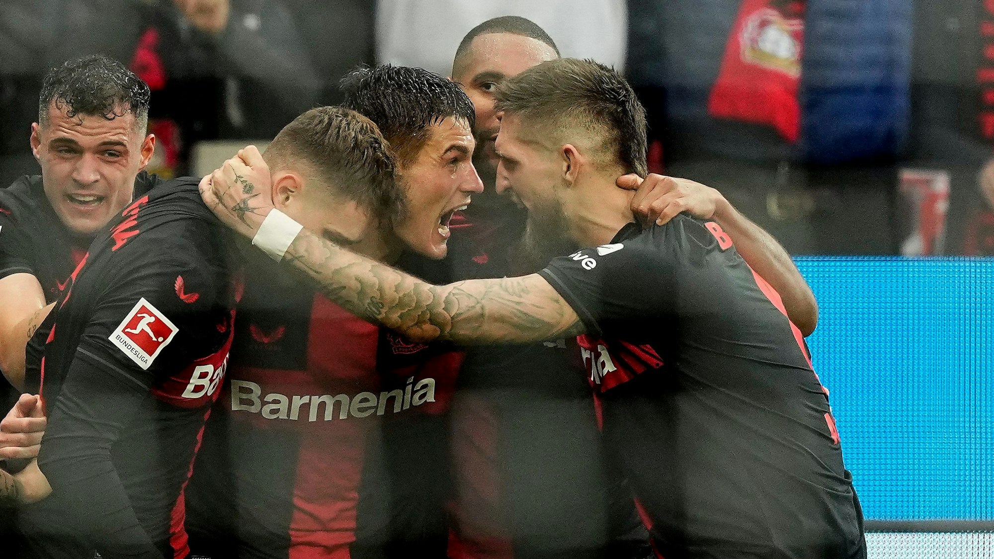 Leverkusen's Patrik Schick, center, celebrates with Leverkusen's Robert Andrich, right, after scoring the decisive goal during the German Bundesliga soccer match between Bayer Leverkusen and TSG Hoffenheim at the BayArena in Leverkusen, Germany, Saturday, March 30, 2024. (AP Photo/Martin Meissner)