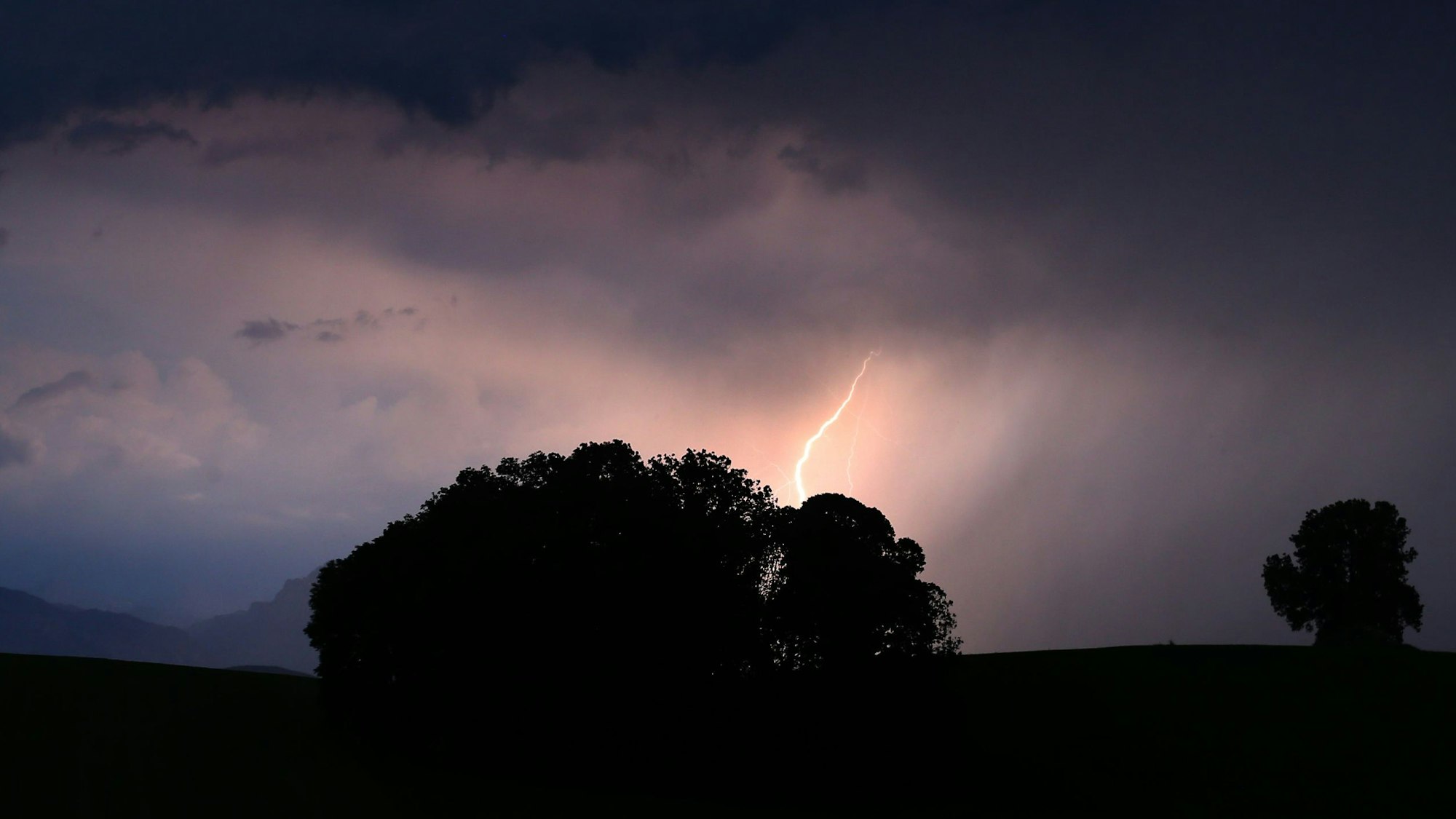 Ein Blitz entlädt sich während eines Unwetters in den Alpen. Am Osterwochenende werden massive Regenfälle mit bis zu 300 Litern pro Quadratmeter erwartet. (Archivbild)