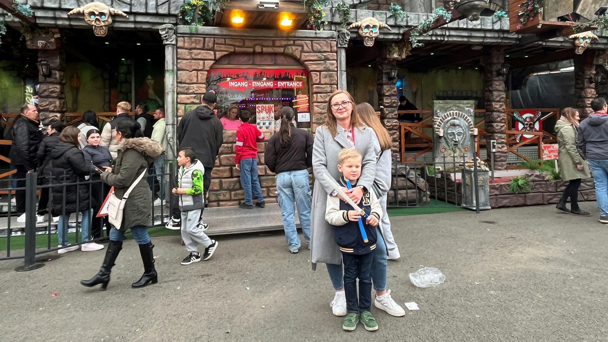 Barbara Nowakowska steht mit ihrem Sohn vor dem Gruselkabinett auf der Deutzer Kirmes.