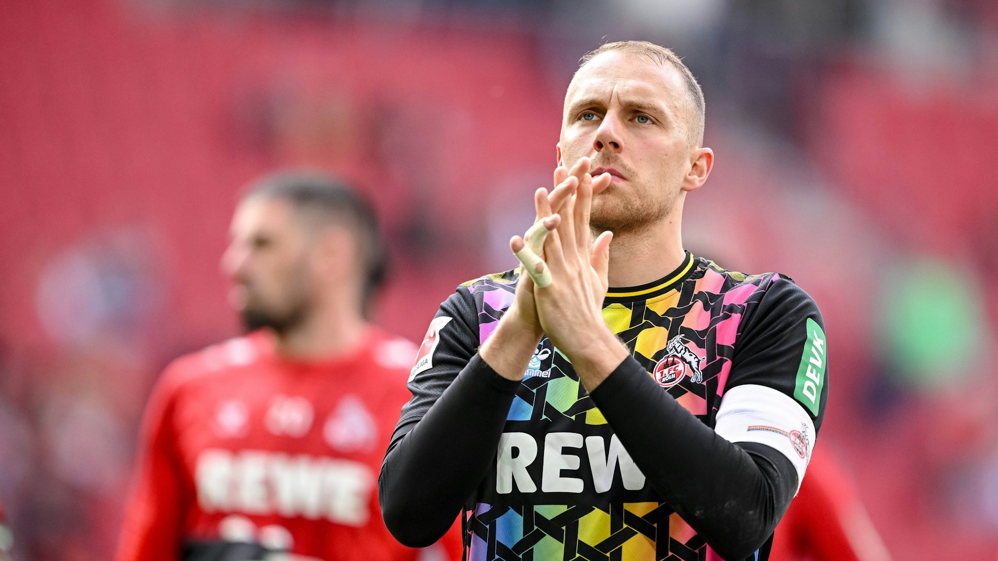 Marvin Schwäbe, Torhüter des 1. FC Köln, applaudiert nach dem 1:1 beim FC Augsburg den mitgereisten Fans.