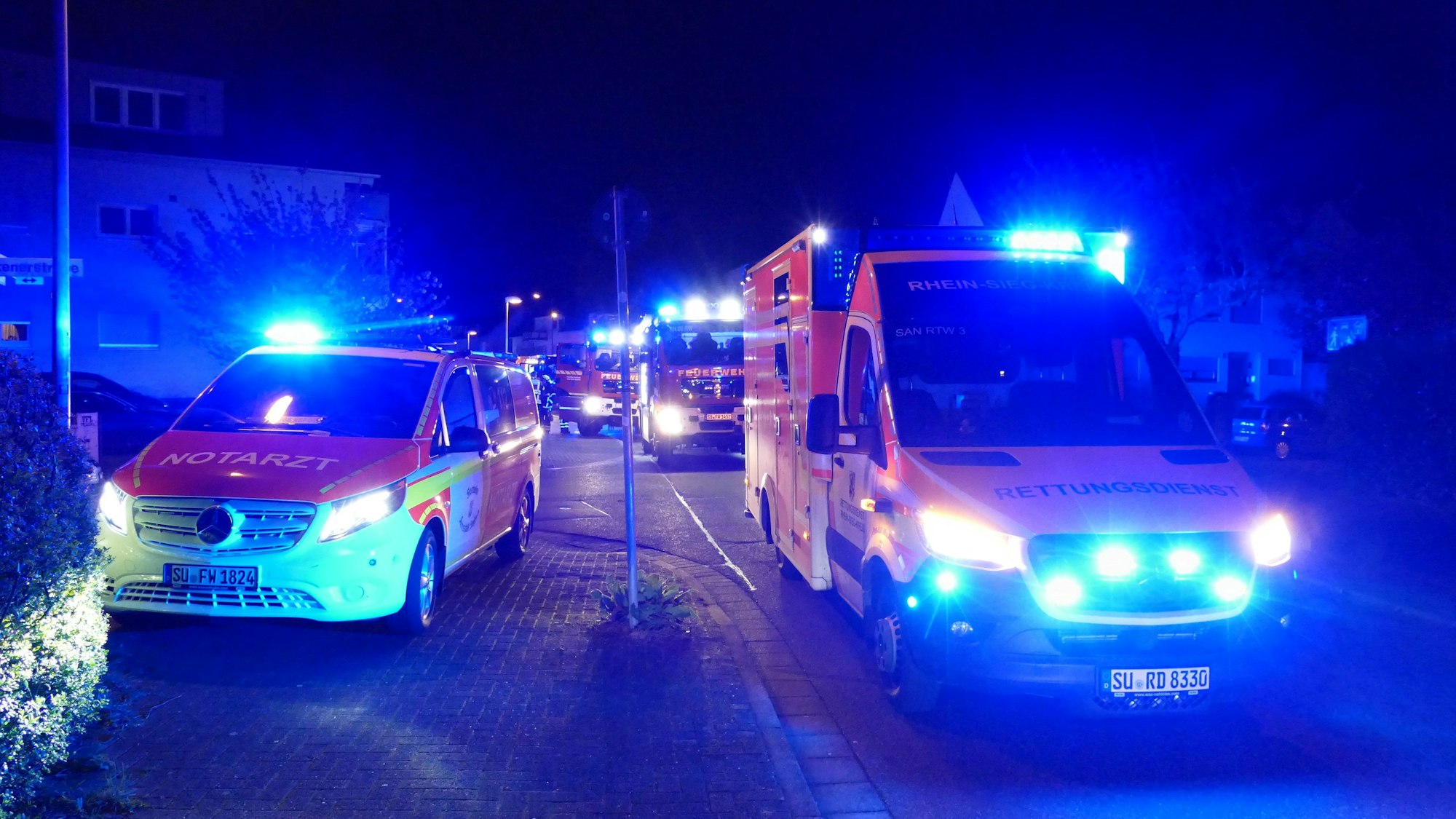 Fahrzeuge von Rettungsdienst und Feuerwehr stehen umher.