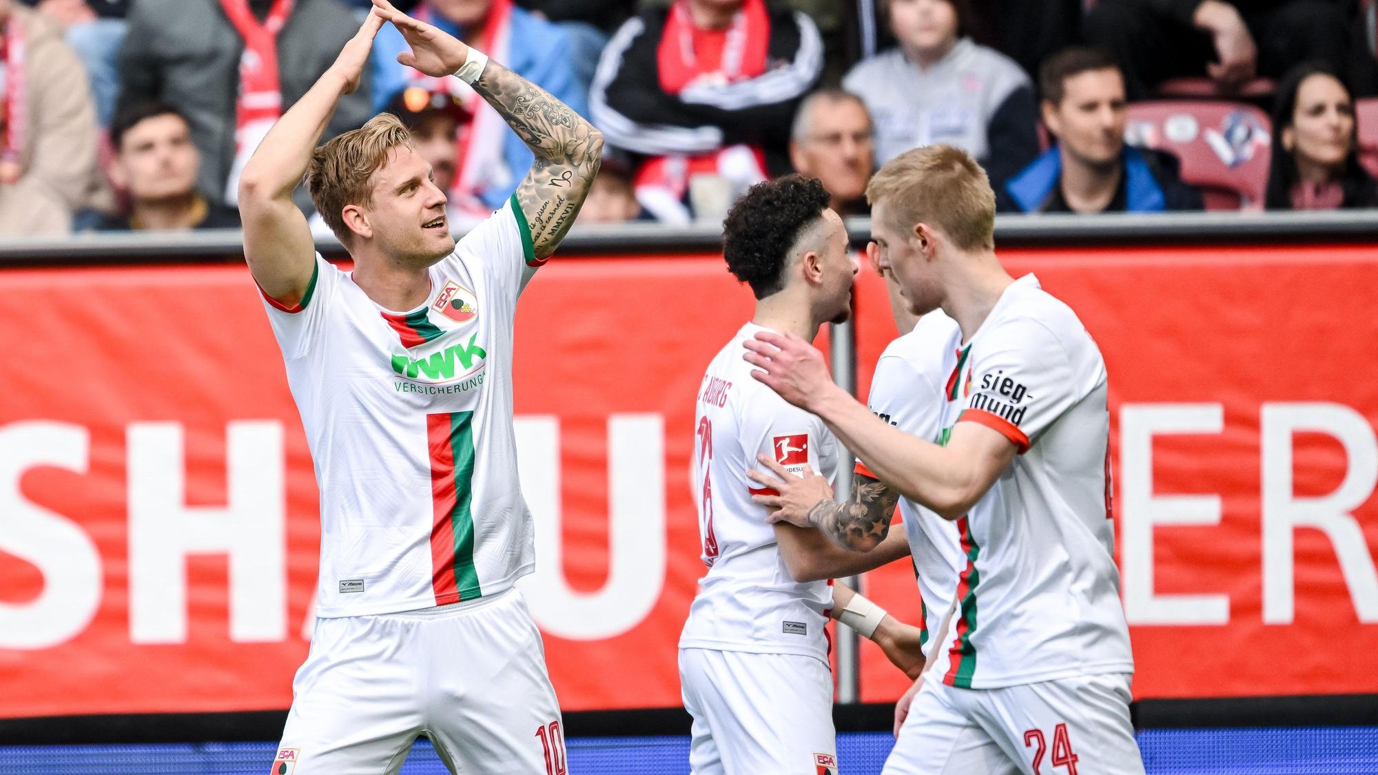 Augsburgs Arne Maier (l), Ruben Vargas (M) und Fredrik Jensen jubeln nach dem 1:0.
