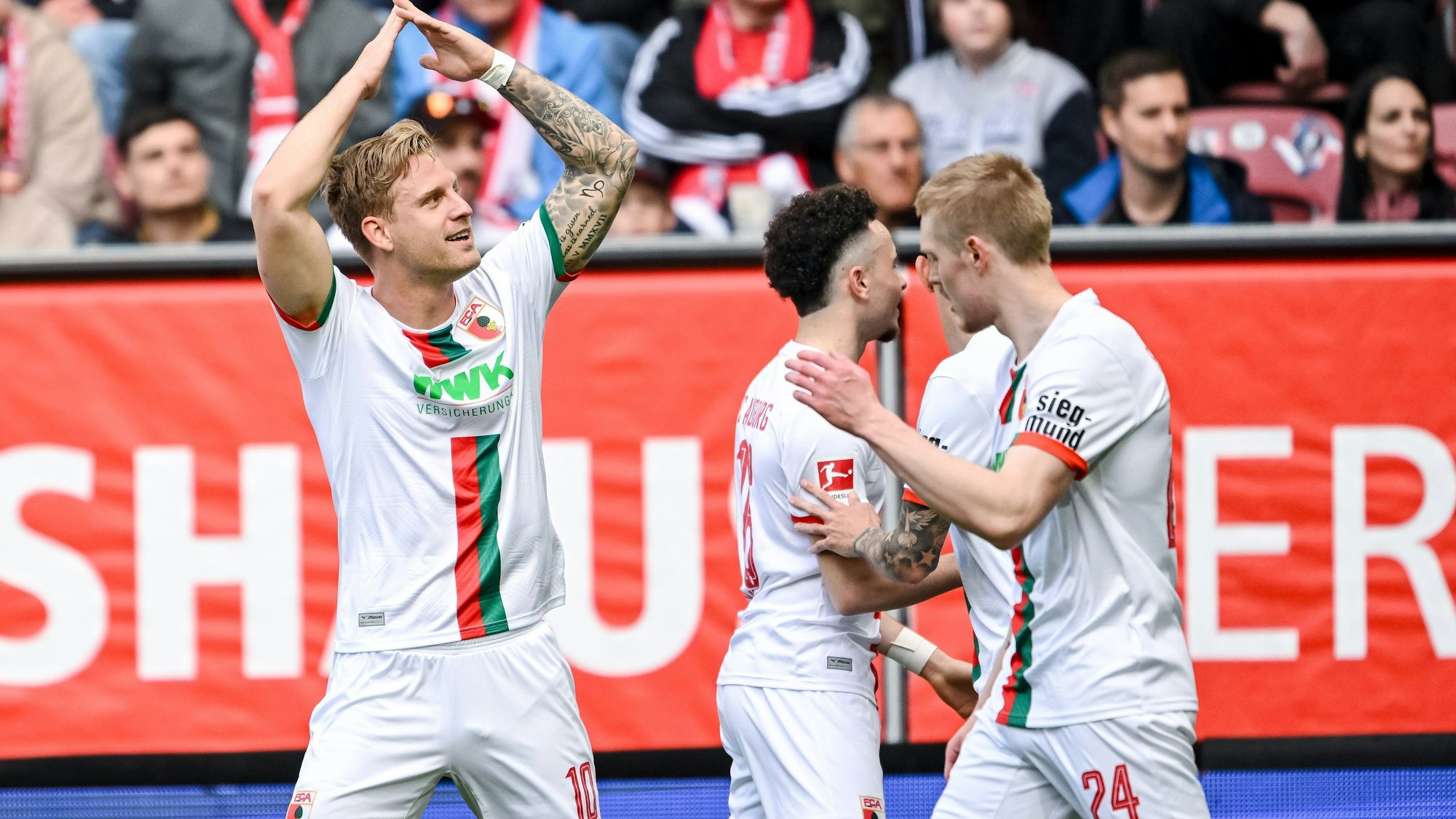 Augsburgs Arne Maier (l), Ruben Vargas (M) und Fredrik Jensen jubeln nach dem 1:0.