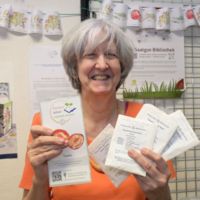 Bücherei-Leiterin Barbara Dinges hält Tütchen mit Pflanzensamen in den Händen.