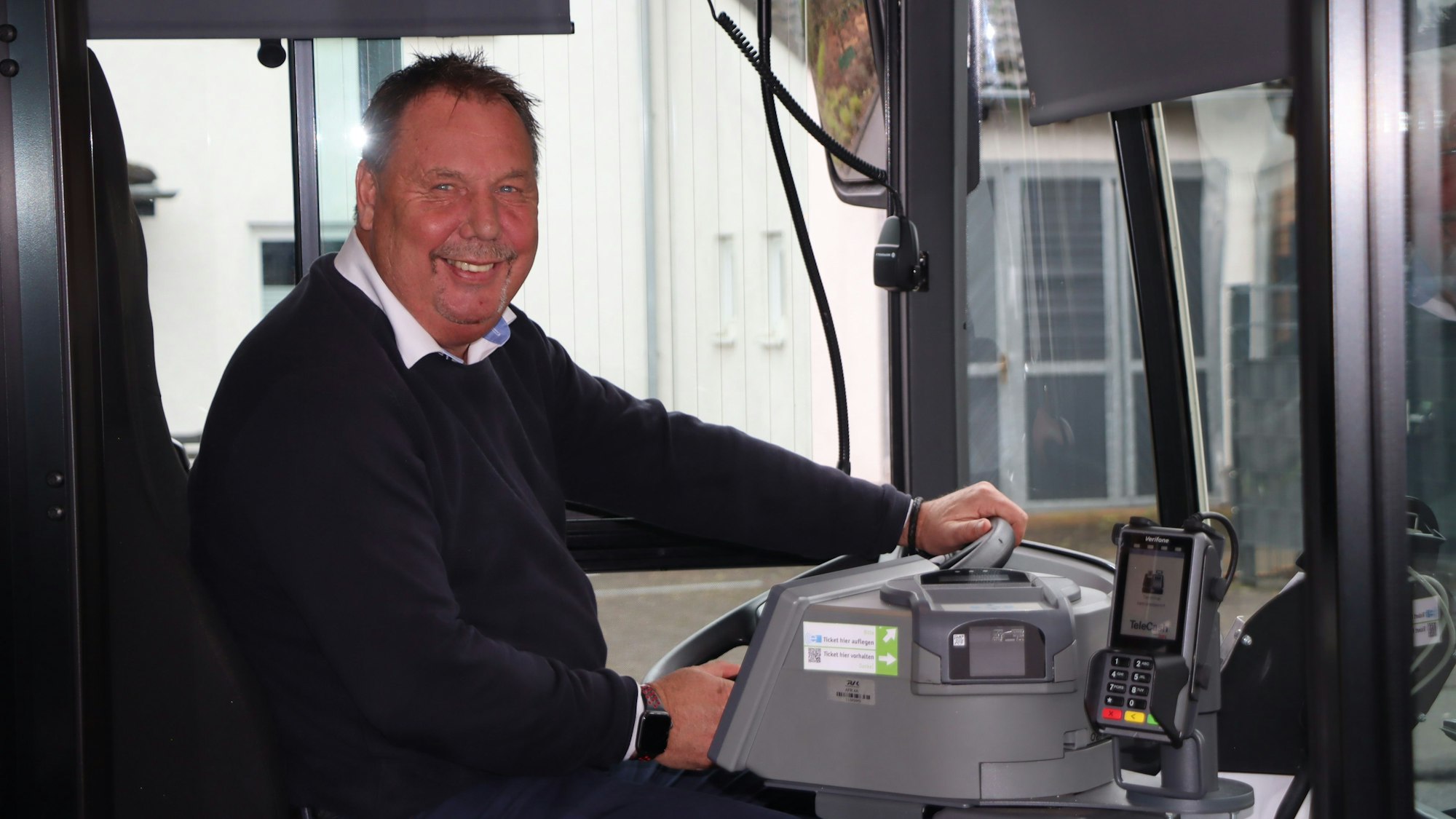 Zu sehen ist ein Mann am Steuer eines Busses.