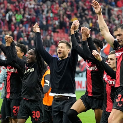 Leverkusen's head coach Xabi Alonso, center, celebrates with his team in front of supporters after winning the German Bundesliga soccer match between Bayer Leverkusen and TSG Hoffenheim at the BayArena in Leverkusen, Germany, Saturday, March 30, 2024. (AP Photo/Martin Meissner)