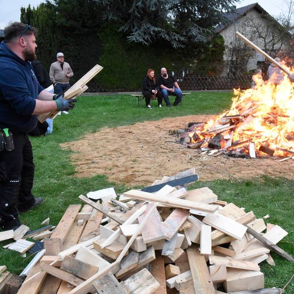 Zu sehen sind die Aktiven der Maigesellschaft beim Entfachen des Osterfeuers.