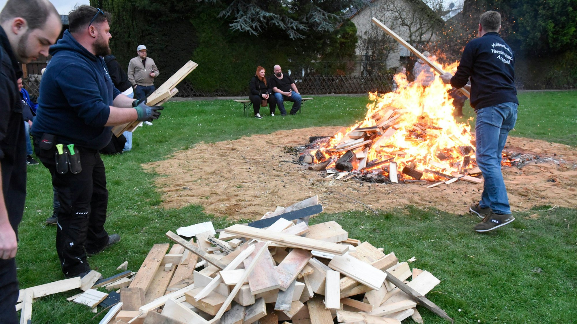 Zu sehen sind die Aktiven der Maigesellschaft beim Entfachen des Osterfeuers.