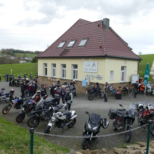 Viele Motorräder stehen auf dem Parkplatz vor einer Gaststätte.
