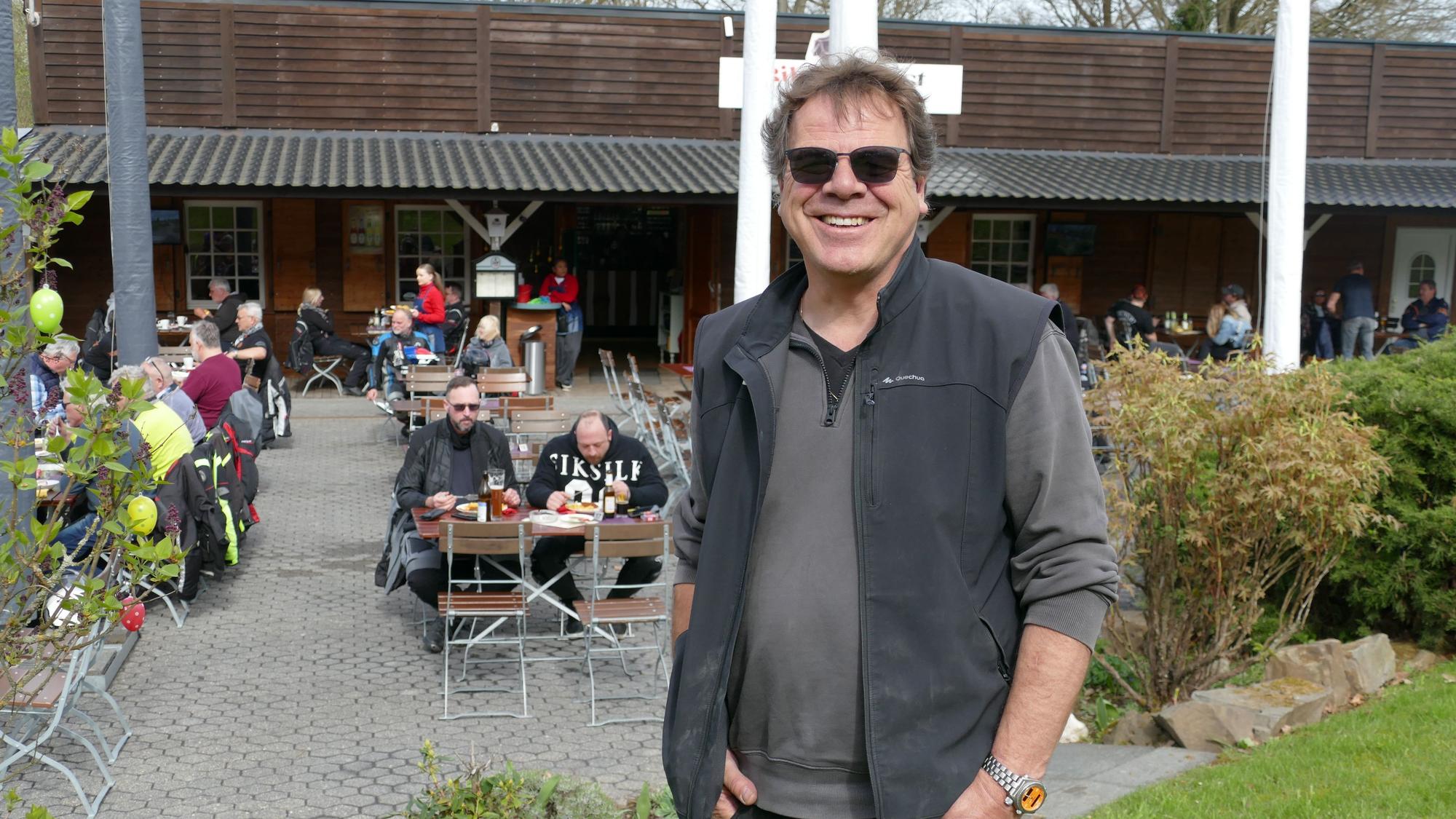 Ein Mann mit Sonnenbrille grinst in die Kamera.