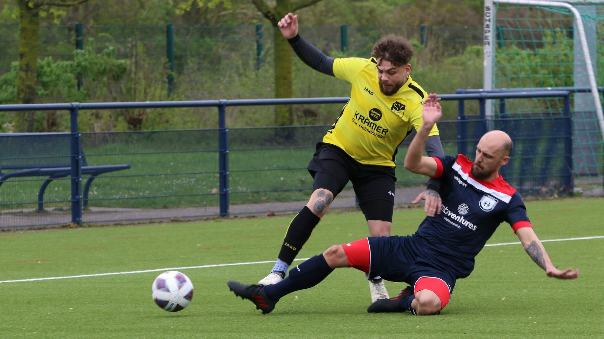 Ein Fußballer stoppt einen Flankenlauf mithilfe eine Grätsche.